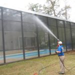 A professional cleaning service cleaning a pool cage enclosure in the Golden Eagle neighborhood of Leon County, Florida.