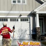 A photo of Nick Loomis, the owner of Hot Water Pressure Washing & Soft Wash, soft washing a Tallahassee home with Hardie board siding.