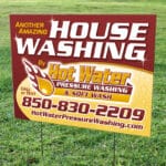 Yard sign advertising hot water pressure washing and soft wash services in Tallahassee, Florida.