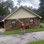 A soft washing service cleaning a brick home.